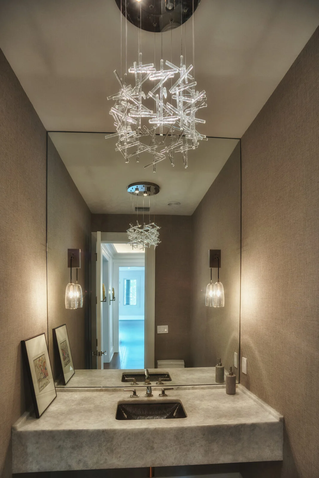 Powder room with grasscloth walls and crystal chandelier