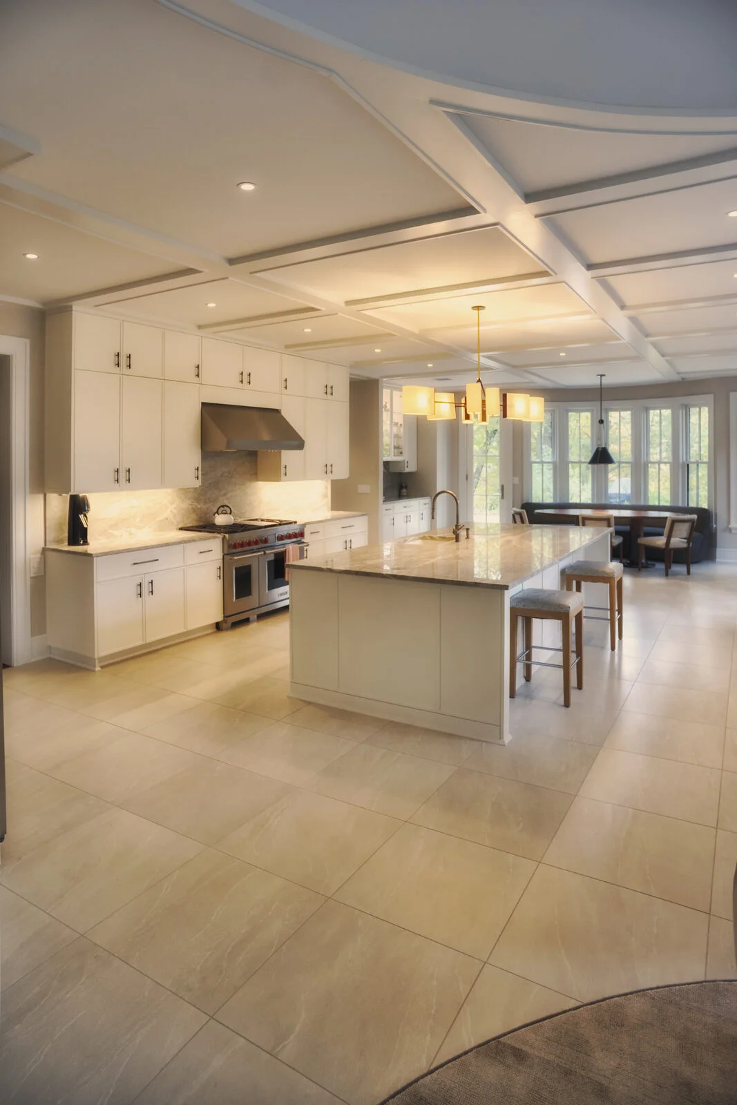 Kitchen range wall — Wolf range, stone backsplash, and counter stools